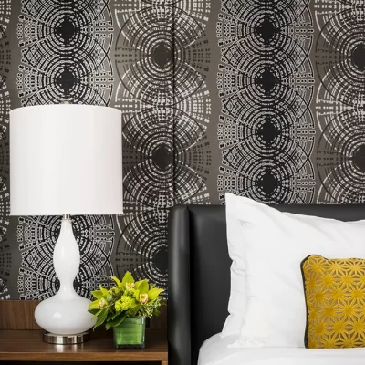 Hotel Arts Studio guest room king bed with decorative headboard and nightstand
